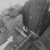 Fallgradeのスクリーンショット。霧の中の高層ビル群を見下ろすモノクロ調の画面