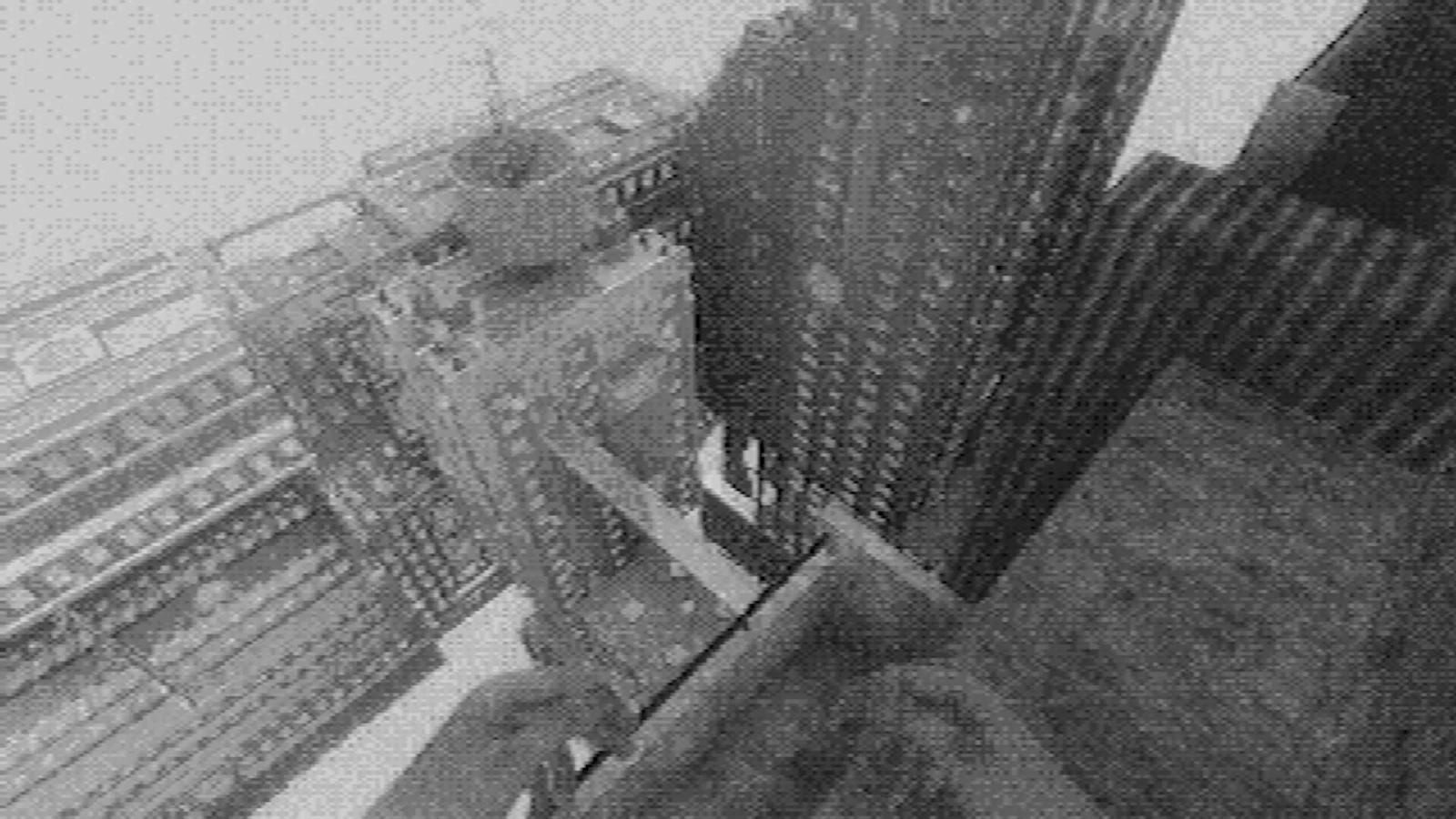 Fallgradeのスクリーンショット。霧の中の高層ビル群を見下ろすモノクロ調の画面